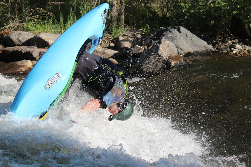 Grant Kashner executes a flipping maneuver during the June 22 Kayak Rodeo at Clear Creek Whitewater Park.